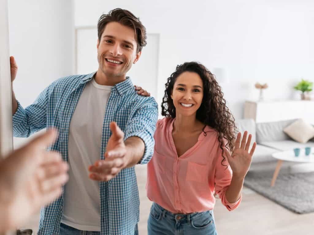 a man and woman standing in a room with their hands out